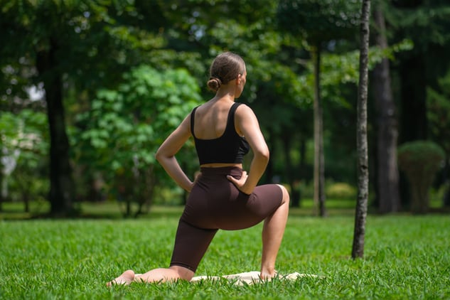 Person doing a lunge stretch outdoors to support physio recovery and rehabilitation progress