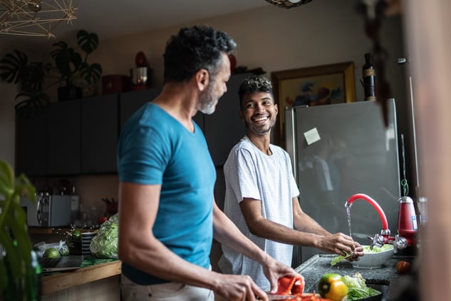 Two men preparing healthy food at home to support recovery and wellbeing